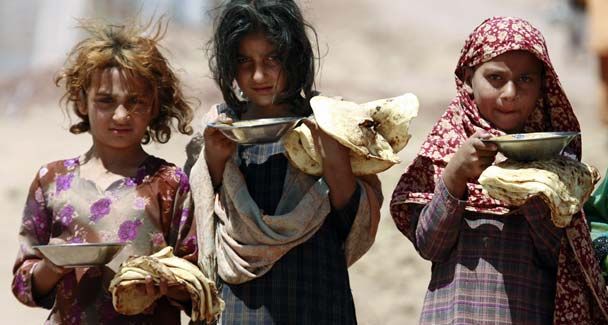 Children carrying donated food bags from a hunger relief outreach